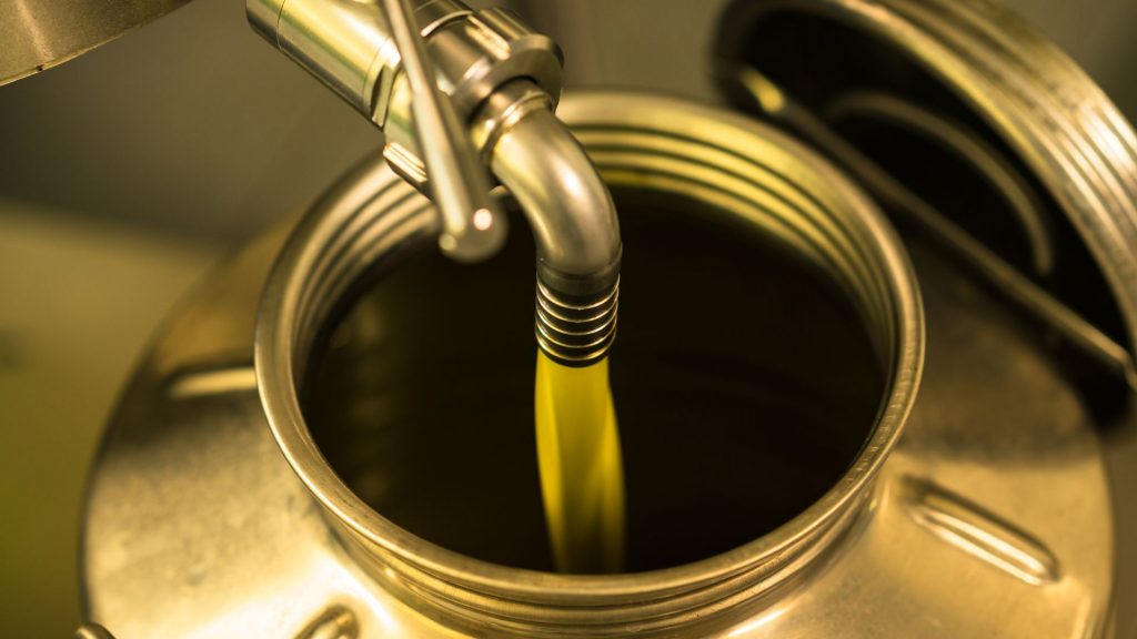 Aceite de oliva virgen extra cayendo en una lata